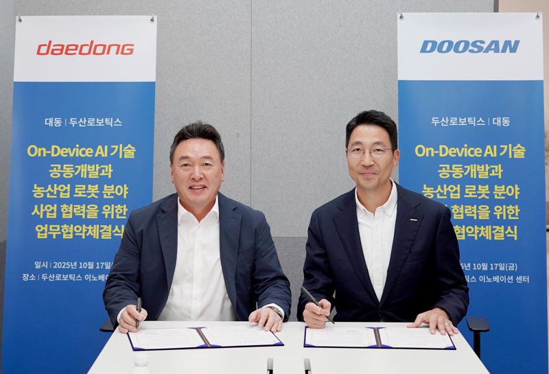 지난 17일 경기도 성남시 분당구에 위치한 두산로보틱스 이노베이션 센터에서 열린 온디바이스 인공지능(AI) 기술 공동개발과 농산업 로봇 분야 사업 협력을 위한 업무협약 체결식에서 원유현 대동 대표이사(왼쪽)와 김민표 두산로보틱스 대표가 협약서에 서명을 하고 있다. 대동그룹 제공