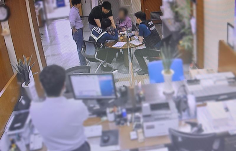 보이스피싱 조직원으로부터 1억원의 상당의 골드바를 구입하라는 지시를 받고 은행에 적금을 찾으러 온 70대가 은행원의 도움으로 위기를 넘긴 뒤 경찰관에게 당시 상황을 설명하고 있다. 울산경찰청 제공
