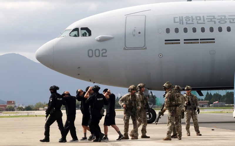 [부산=뉴시스] 하경민 기자 = 2025 APEC 정상회의 대비 대테러 종합훈련이 열린 22일 부산 강서구 제5공중기동비행단 주기장에서 항공특수통제사(CCT) 등이 항공기 인질 테러범을 진압한 뒤 압송하고 있다. 항공기 인질 및 폭발물 테러 상황을 가정한 이날 훈련에는 공군(대테러 초동조치반, 항공특수통제사), 육군 53사단, 부산경찰청 경찰특공대, 김해공항 EOD 등의 유관기간에서 80여 명이 참가했다. 2025.10.22. yulnetphoto@newsis.com