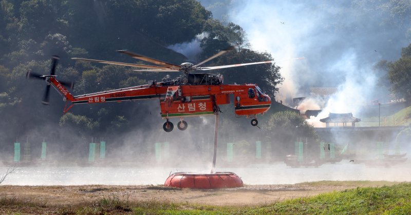 [공주=뉴시스] 강종민 기자 = 22일 충남 공주시 금강변에서 열린 2025 산불진화 통합훈련에서 산불진화헬기가 물을 빨아들이고 있다. 2025.10.22. ppkjm@newsis.com