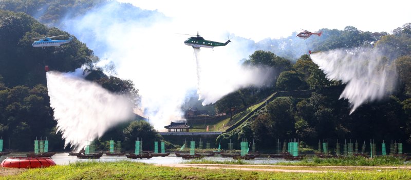 [공주=뉴시스] 강종민 기자 = 22일 충남 공주시 금강변에서 열린 2025 산불진화 통합훈련에서 산불진화헬기들이 방수하고 있다. 2025.10.22. ppkjm@newsis.com