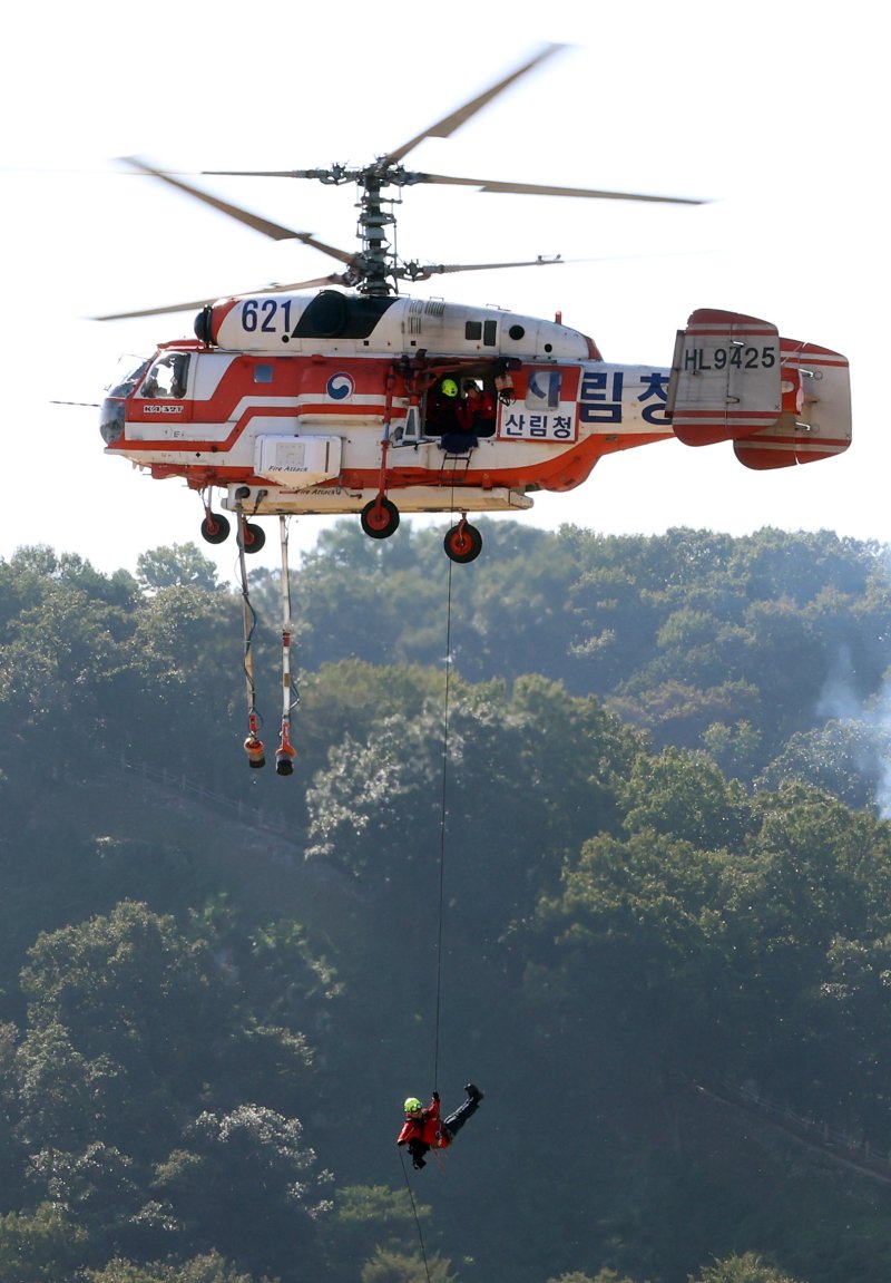 [공주=뉴시스] 강종민 기자 = 22일 충남 공주시 금강변에서 열린 2025 산불진화 통합훈련에서 산불진화요원이 헬기레펠을 하고 있다. 2025.10.22. ppkjm@newsis.com
