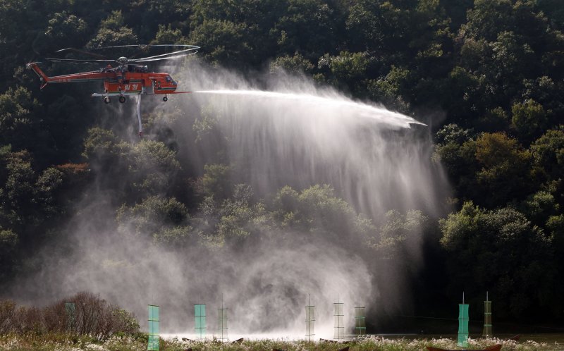 [공주=뉴시스] 강종민 기자 = 22일 충남 공주시 금강변에서 열린 2025 산불진화 통합훈련에서 산불진화헬기들이 방수하고 있다. 2025.10.22. ppkjm@newsis.com