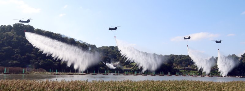 [공주=뉴시스] 강종민 기자 = 22일 충남 공주시 금강변에서 열린 2025 산불진화 통합훈련에서 산불진화헬기들이 방수하고 있다. 2025.10.22. ppkjm@newsis.com
