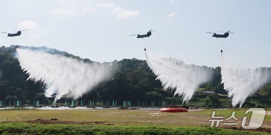 22일 충남 공주 금강변에서 열린 2025 산불진화 통합훈련에서 산불진화 헬기들이 공중 진화를 전개하고 있다. (공주=뉴스1) 김기태 기자