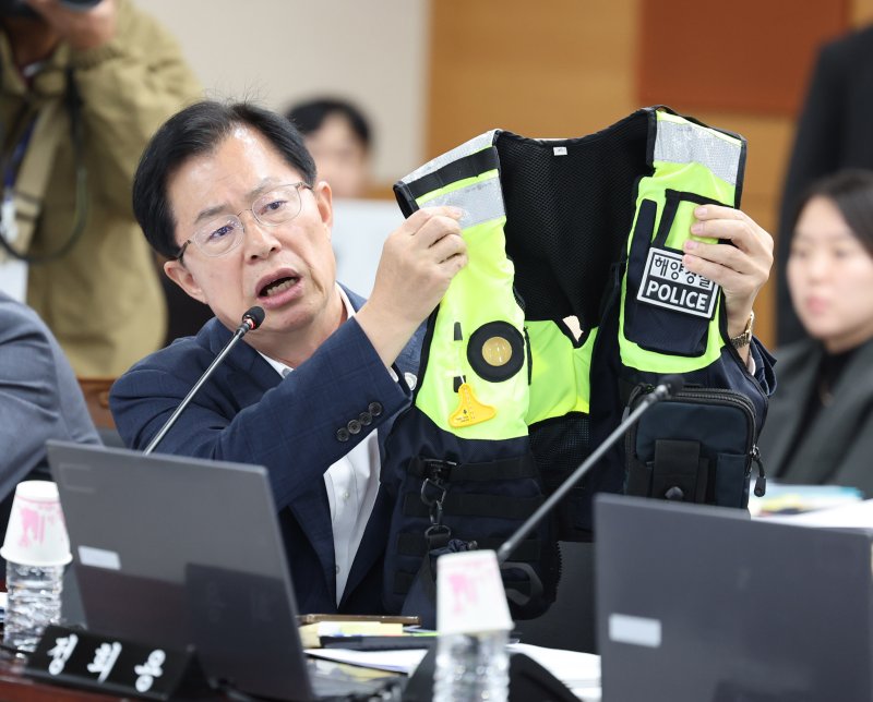 [인천=뉴시스] 전진환 기자 = 이만희 국민의힘 의원이 22일 인천 연수구 해양경찰청에서 열린 국회 농림축산식품해양수산위원회의 해양경찰청 등에 대한 국정감사에서 김용진 해양경찰청장에게 고 이재석 경사의 사망 관련 질의를 하며 순찰용 조끼를 들어보이고 있다 2025.10.22. amin2@newsis.com