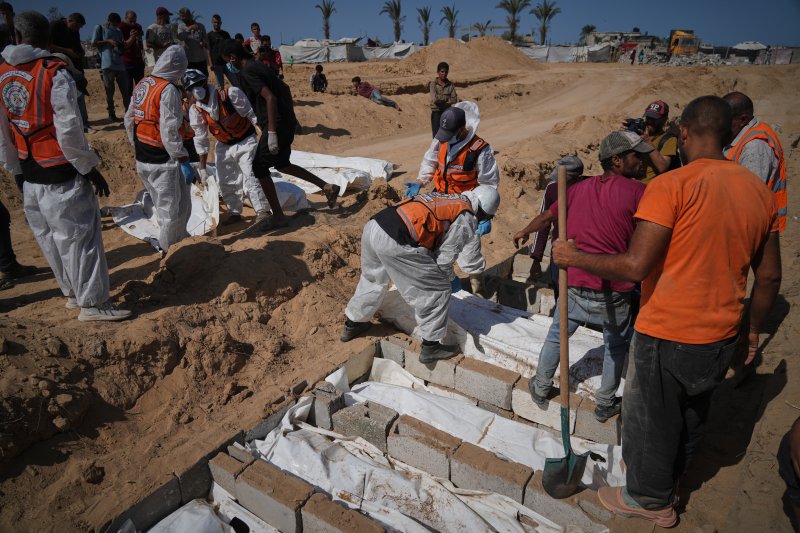 [데이르알발라=AP/뉴시스] 22일(현지 시간) 이스라엘에서 송환된 신원 미상의 팔레스타인인 시신들이 가자지구 데이르알발라에서 집단 매장되고 있다. 이스라엘은 하마스와 휴전협정에 따라 지금까지 팔레스타인인 시신 150구를 인계한 것으로 알려졌다. 2025.10.23.