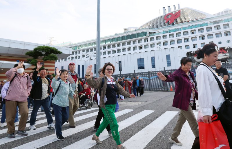 중국 단체관광객의 무비자 입국이 시작된 29일 오전 크루즈를 타고 방한한 중국인 관광객들이 인천 연수구 인천항크루즈터미널을 통해 입국하며 손을 흔들고 있다. 정부는 9월 29일부터 내년 6월 30일까지 중국인 단체관광객의 무비자 입국을 허용하기로 했다. 이 기간 중국인 단체관광객들은 15일 범위 내에서 무비자로 입국해 관광할 수 있다. 2025.9.29/뉴스1 ⓒ News1 오대일 기자