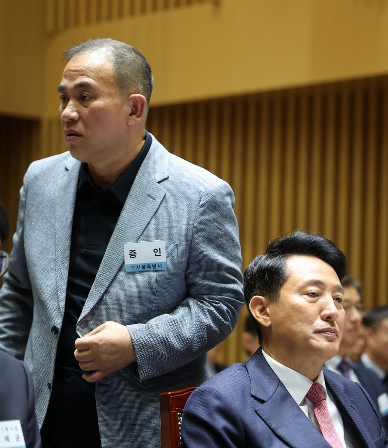 [서울=뉴시스] 김선웅 기자 = '정치브로커'로 알려진 명태균 씨가 23일 서울시청에서 열린 국회 행정안전위원회의 서울특별시에 대한 국정감사에 증인으로 출석해 오세훈 서울시장 뒤를 지나 증언대로 향하고 있다. 2025.10.23. mangusta@newsis.com