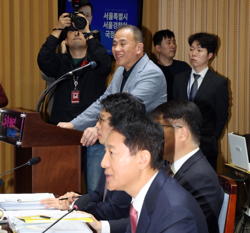 '정치 브로커' 명태균씨가 23일 오후 서울 중구 서울시청에서 열린 국회 행정안전위원회 서울시청 국정감사에서 오세훈 서울시장의 발언을 듣고 미소를 보이고 있다. 2025.10.23/뉴스1 ⓒ News1 황기선 기자