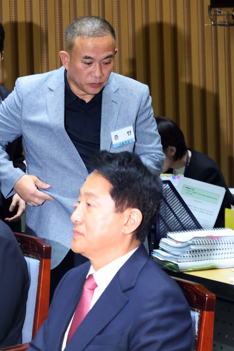 '정치 브로커' 명태균씨가 23일 오후 서울 중구 서울시청에서 열린 국회 행정안전위원회 서울시청 국정감사에서 의원질의를 마치고 오세훈 서울시장 뒤로 이동하고 있다. 2025.10.23/뉴스1 ⓒ News1 황기선 기자