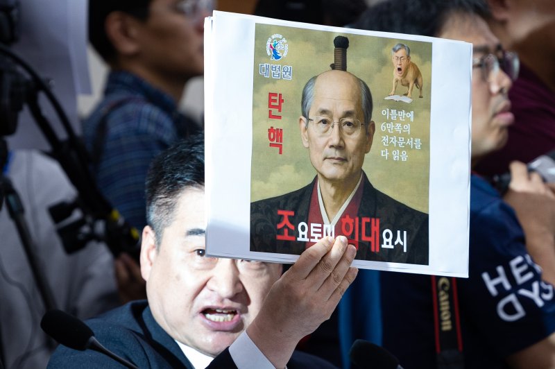 최혁진 무소속 의원이 지난 13일 서울 여의도 국회에서 열린 법제사법위원회의 대법원 등에 대한 국정감사에서 조희대 대법원장에게 질의하며 손팻말을 들어보이고 있다. 2025.10.13/뉴스1 ⓒ News1 유승관 기자