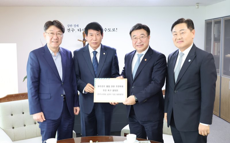 [전주=뉴시스]윤난슬 기자 = 남관우 전주시의장(왼쪽 두번째)은 윤 장관에게 '완주·전주 통합 주민투표 추진 촉구 결의안'을 직접 전달했다. (사진=전주시의회 제공) 2025.10.24. photo@newsis.com