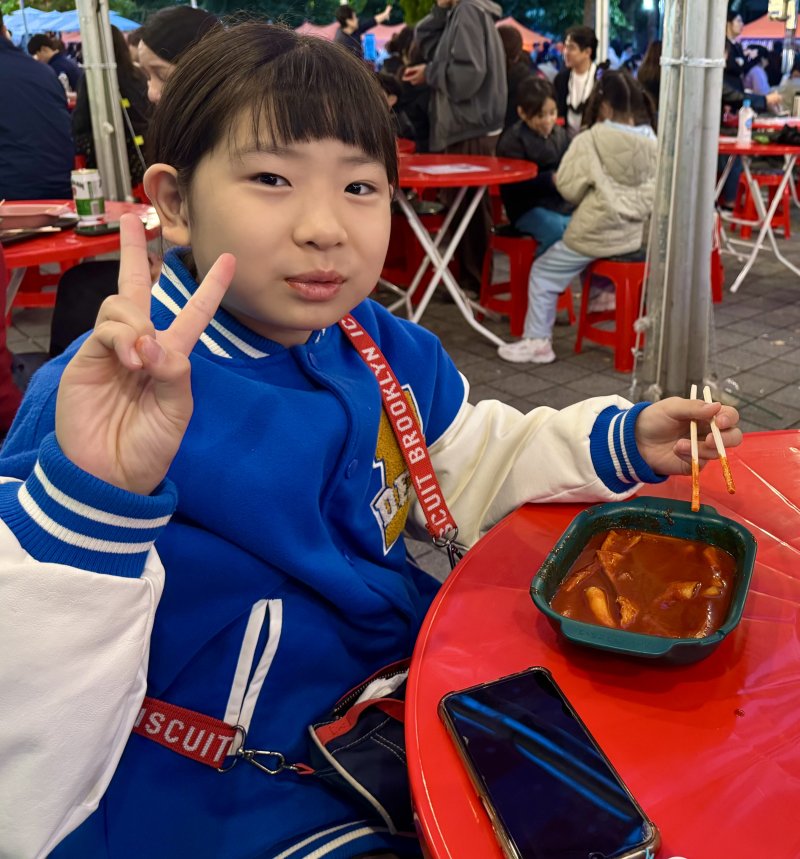 [대구=뉴시스] 정재익 기자 = 24일 대구 북구 고성동 대구iM뱅크파크 일대에서 열린 '제5회 떡볶이 페스티벌'에서 떡볶이를 먹던 한 아이가 웃음 짓고 있다. 2025.10.24. jjikk@newsis.com *재판매 및 DB 금지