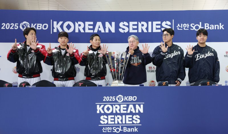 [서울=뉴시스] 김진아 기자 = 염경엽 LG 트윈스 감독과 김경문 한화 이글스 감독을 비롯한 선수들이 25일 서울 잠실야구장에서 열린 2025 KBO 한국시리즈 미디어데이에서 우승 트로피와 기념촬영을 하던 중 손가락으로 몇 차전 경기까지 갈 것인지 표시하고 있다. 왼쪽부터 LG 트윈스 임찬규, 박해민, 염 감독, 한화 이글스 김 감독, 채은성, 정우주. 2025.10.25. bluesoda@newsis.com
