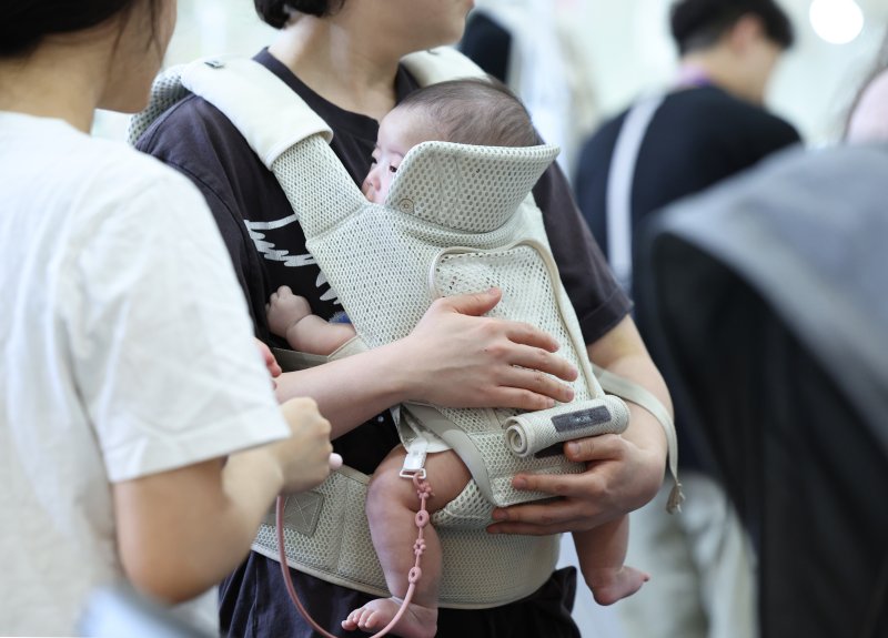 [서울=뉴시스] 김진아 기자 = 14일 서울 강남구 코엑스에서 열린 제48회 베페 베이비페어에서 관람객들이 아기띠를 체험해보고 있다. 2025.08.14. bluesoda@newsis.com