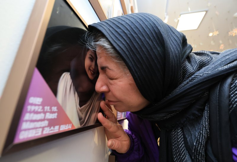 [서울=뉴시스] 김근수 기자 = 10·29 이태원참사 외국인 유가족이 26일 오후 서울 종로구 별들의 집에 방문해 희생자의 사진에 얼굴을 대고 있다. (공동취재) 2025.10.26. photo@newsis.com