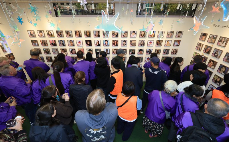 [서울=뉴시스] 김근수 기자 = 10·29 이태원참사 외국인 유가족들이 26일 오후 서울 종로구 별들의 집에 방문해 벽에 걸린 희생자의 사진을 살펴보고 있다. (공동취재) 2025.10.26. photo@newsis.com