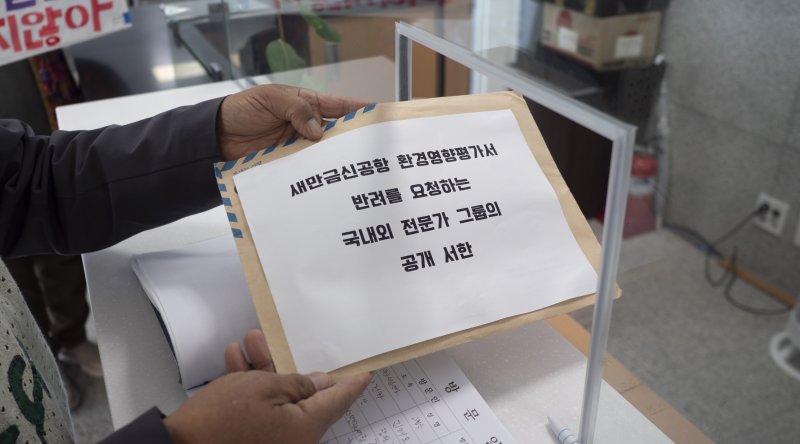 [전주=뉴시스] 강경호 기자 = 새만금신공항백지화공동행동 등 시민단체 관계자가 27일 전북 전주시 덕진구 전북지방환경청 민원실 창구에서 '국내외 전문가 그룹의 새만금 신공항 환경영향평가서 반려 요청 서한문'를 제출하고 있다. 2025.10.27. lukekang@newsis.com