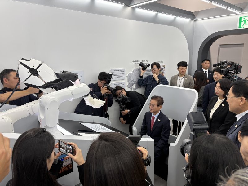 [안동=뉴시스] 이철우 경북지사가 27일 경주세계문화엑스포공원 내 아시아태평양경제협력체(APEC) 정상회의 경제전시장에 마련된 'K-IP콘텐츠관'에서 AI 드로잉 로봇을 체험하고 있다. (사진=경북도 제공) 2025.10.27 photo@newsis.com *재판매 및 DB 금지