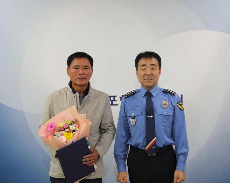 채수준 목포해양경찰서장(오른쪽)이 27일 전복된 어선에서 생명을 구한 황동연 선장(63)에게 표창장을 수여한 뒤 기념사진을 찍고 있다. (목포해경 제공. 재판매 및 DB 금지)