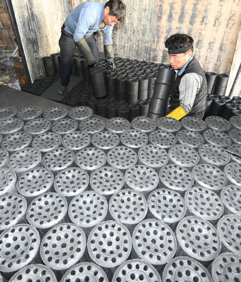 [화성=뉴시스] 김종택 기자 = 초겨울 날씨를 보인 27일 경기 화성시 배양동 한 연탄 출하장에서 관계자들이 분주하게 연탄을 트럭으로 옮기고 있다. 2025.10.27. jtk@newsis.com