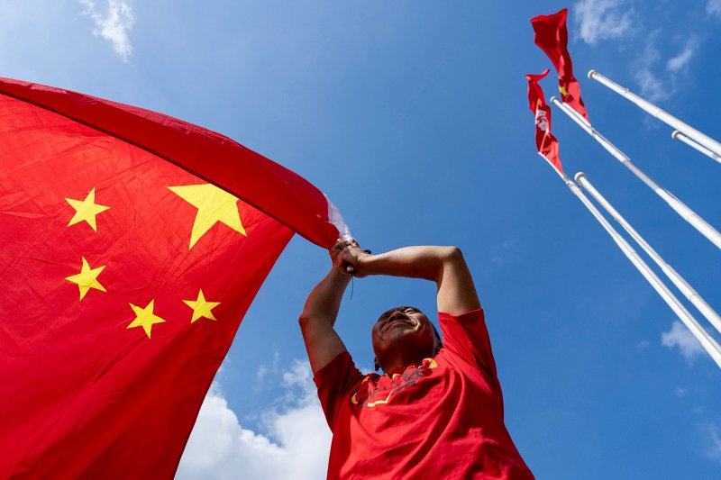 [홍콩=AP/뉴시스] 중화인민공화국 건국(국경절) 76주년인 1일(현지 시간) 홍콩에서 친중 성향 지지자가 중국 국기를 펄럭이며 국경절을 축하하고 있다. 2025.10.01.