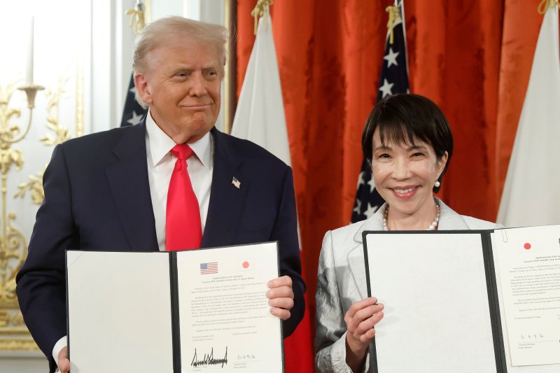 한국에 앞서 일본을 방문한 도널드 트럼프 미국 대통령이 28일 도쿄 아카사카 영빈관에서 다카이치 사나에 일본 총리와 일본의 5500억 달러(약 790조원) 규모 대미 투자가 포함된 미일 무역 합의 이행 의지를 강조하는 문서에 서명한 뒤 들어보이고 있다. AP뉴시스