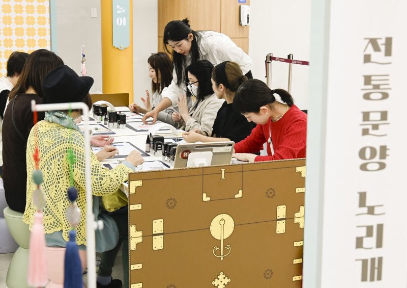 김포공항 이용객이 지난 27일 국제선 터미널에서 진행된 전통문화 체험행사에서 노리개를 만들고 있다. 한국공항공사 제공