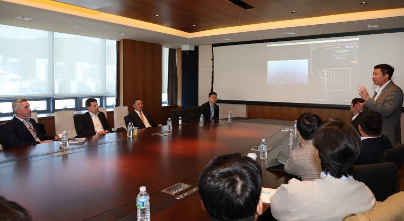 폴 르윈 해벅AI CEO(맨 오른쪽 발표자)가 한화 임직원들에게 하와이 앞 바다에 대기중인 해벅AI의 무인수상정을 한화오션 거제사업장에서 원격통제하는 기술 시연을 선보이고 있다(한화시스템 제공)