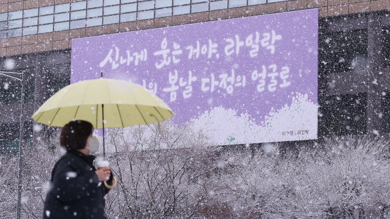 난데없는 3월 대설주의보가 발효된 18일 오전 서울 광화문광장에서 한 시민이 광화문 봄글판 앞으로 지나가고 있다. 2025.3.18/뉴스1 ⓒ News1 박지혜 기자