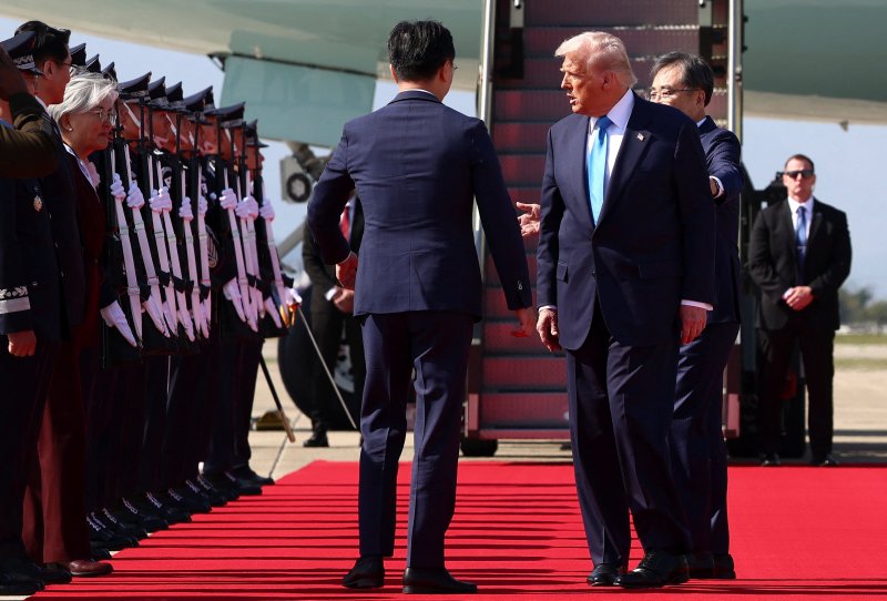 도널드 트럼프 미국 대통령이 29일 한국 부산 김해국제공항에 도착한 직후 조현 외교부 장관의 영접을 받으며 의장대의 사열을 받고 있다. 로이터 연합뉴스