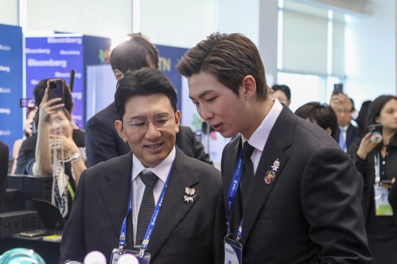 29일 경주 예술의전당에서 열린 'APEC CEO 서밋' 개회식에서 방시혁 하이브 의장과 방탄소년단 RM이 하이브 홍보부스를 관람하고 있다. 하이브 제공