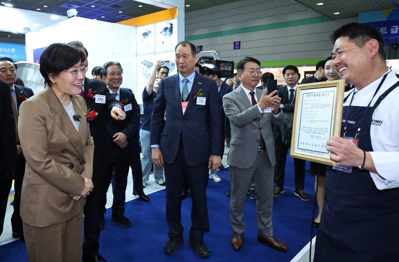 [서울=뉴시스] 최진석 기자 = 송미령 농림축산식품부 장관이 29일 서울 강남구 코엑스에서 열린 '2025 푸드위크 코리아'에서 한부스 관계자의 설명을 들으며 농식품부 녹색기술제품확인서를 바라보고 있다. 2025.10.29. myjs@newsis.com