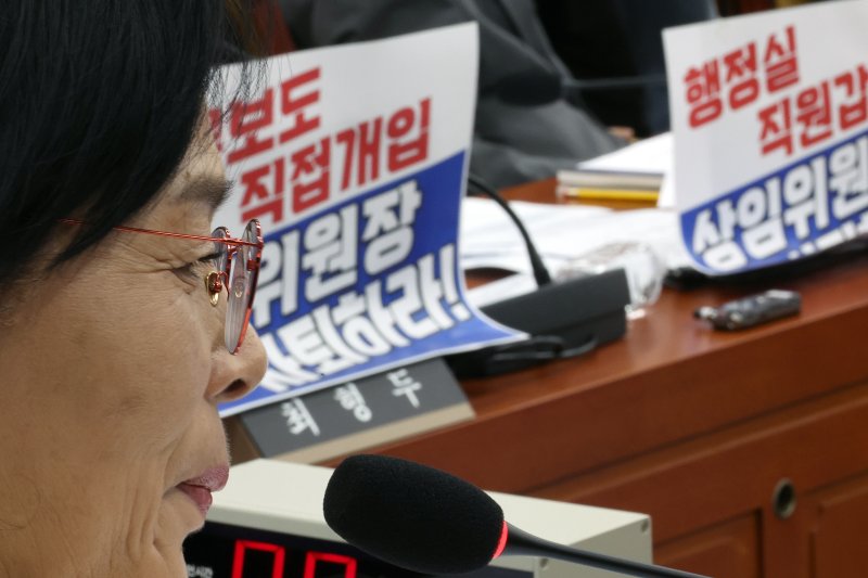 [서울=뉴시스] 김금보 기자 = 최민희 국회 과학기술정보방송통신위원회 위원장이 지난 29일 서울 여의도 국회에서 열린 국정감사에서 미소를 머금고 있다. 국민의힘 의원들이 노트북에 부착한 최 위원장 사퇴 촉구 피켓이 안경에 비치고 있다. 2025.10.29. kgb@newsis.com