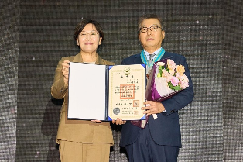 이우봉 풀무원 총괄CEO가 29일 서울 삼성 코엑스에서 열린 ‘푸드위크 코리아 2025’에서 국내 식품산업의 성장 및 발전에 기여한 공로를 인정받아 '은탑산업훈장'을 받았다. 이우봉 총괄CEO(오른쪽)가 송미령 농림축산식품부 장관과 기념 촬영을 하고 있다. (풀무원 제공)