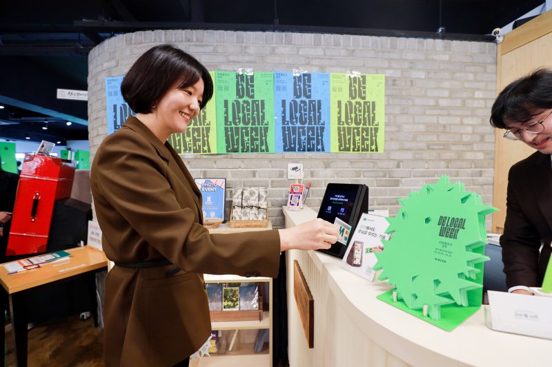 네이버 '비로컬위크' 캠페인 현장에서 네이버페이 오프라인 통합 단말기 ‘Npay 커넥트’로 결제를 진행 중인 최수연 네이버 대표 (네이버 제공)