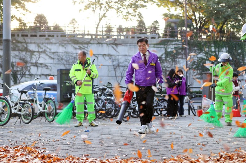 [서울=뉴시스] 이필형 동대문구청장이 환경공무관들과 함께 낙엽 청소에 참여하고 있다. 2025.10.30. (사진=동대문구 제공) *재판매 및 DB 금지