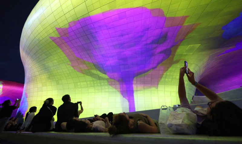 [서울=뉴시스] 조성우 기자 = 28일 오후 서울 중구 동대문디자인플라자(DDP)에서 열린 '서울라이트 DDP 2025 가을'을 찾은 시민들과 외국인 관광객들이 미디어파사드 작품을 관람하고 있다. 2025.08.28. xconfind@newsis.com