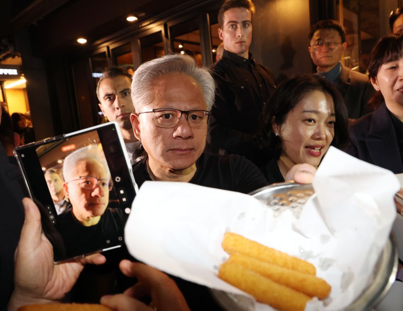 [서울=뉴시스] 정병혁 기자 = 젠슨 황 엔비디아 최고경영자(CEO)가 30일 서울 강남구 삼성역 인근 깐부치킨에서 이재용 삼성전자 회장과 정의선 현대차그룹 회장과의 '치맥회동' 중 시민들에게 치즈스틱을 건네고 있다. (공동취재) 2025.10.30. photo@newsis.com