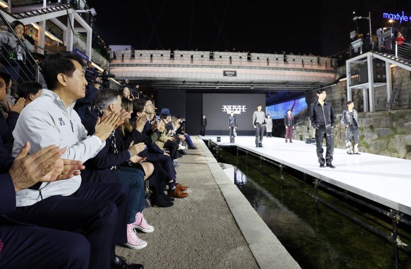 [서울=뉴시스] 이영환 기자 = 오세훈 서울시장이 30일 오후 서울 종로구 청계천 오간수교에서 열린 청계천 야간경관 점등식에서 진행된 패션쇼를 관람하고 있다. 2025.10.30. 20hwan@newsis.com