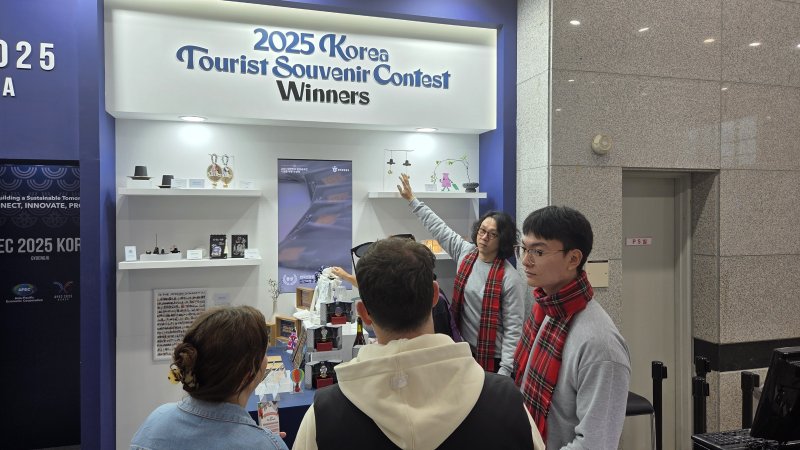 31일 경주역에 마련된 APEC 기념 굿즈 팝업스토어. 외국인 관광객이 '갓'이 달린 풍경 소리를 듣고 있다.2025.10.31/뉴스1 ⓒ News1 이성덕 기자