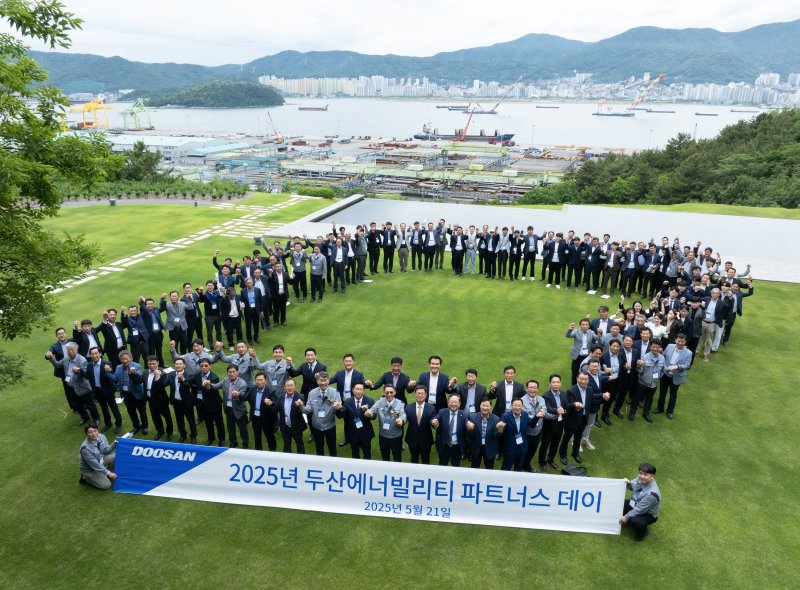 [서울=뉴시스] 지난 5월 두산에너빌리티 창원 본사에서 진행된 ‘2025년 두산에너빌리티 파트너스 데이’에서 참석자들이 기념촬영을 하고 있다.(사진=두산에너빌리티 제공). 2025.10.31. photo@newsis.com *재판매 및 DB 금지