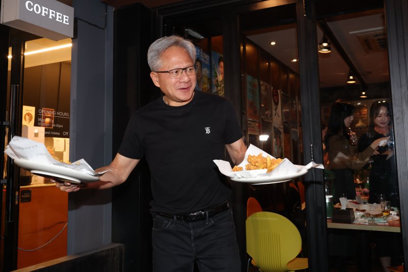 [서울=뉴시스] 정병혁 기자 = 젠슨 황 엔비디아 최고경영자(CEO)가 30일 오후 서울 강남구 삼성역 인근 깐부치킨 매장에서 이재용 삼성전자 회장, 정의선 현대차그룹 회장과 치킨 회동 중 밖으로 나와 시민들에게 치킨을 나눠주고 있다. (공동취재) 2025.10.30. photo@newsis.com