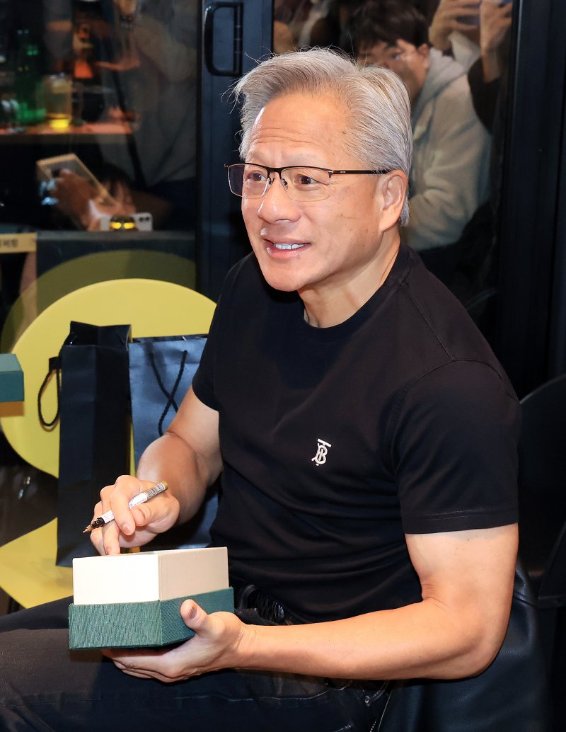 [서울=뉴시스] 정병혁 기자 = 젠슨 황 엔비디아 최고경영자(CEO)가 30일 서울 강남구 삼성역 깐부치킨 매장에서 이재용 삼성전자 회장, 정의선 현대차그룹 회장과의 치맥 회동 중 선물에 사인하고 있다. (공동취재) 2025.10.30. photo@newsis.com