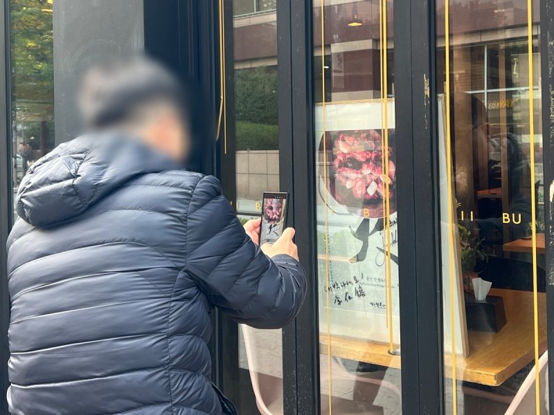 깐부치킨 포스터 앞에서 '인증 사진' 찍는 시민 (출처=연합뉴스)