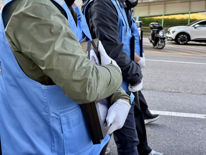 [서울=뉴시스] 한이재 기자 = 1일 오후 서울 용산구 일대에서 12.29 무안공항 제주항공 여객기 참사 유가족 협의회가 주관한 300일 진상규명 촉구 집회에서 한 유가족이 영정을 품에 안고 걷고 있다. 2025.11.01. nowone@newsis.com