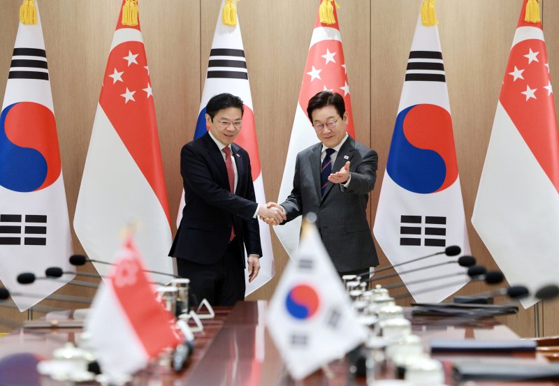 이재명 대통령이 2일 용산 대통령실에서 로런스 웡 싱가포르 총리와 정상회담 기념촬영 후 자리를 안내하고 있다. 연합뉴스