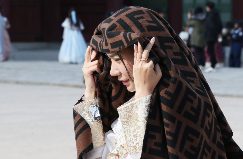 추위가 찾아온 2일 오후 서울 종로구 경복궁을 찾은 외국인 관광객이 목도리로 머리를 감싸고 있다. 기상청은 이날 밤 9시부터 서울과 경기, 인천, 충청, 전북, 경상 서부 등에 한파주의보를 발령한다고 밝혔다. 2025.11.2/뉴스1 ⓒ News1 장수영 기자