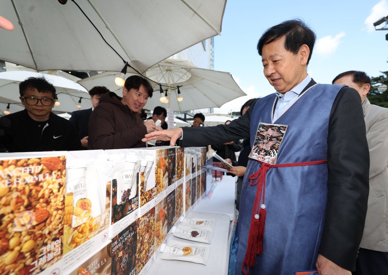 [서울=뉴시스] 홍효식 기자 = 2일 서울 중구 두타몰 광장에서 코리아 그랜드 페스티벌의 일환으로 열린 소상공인 우수제품 판매전 '모두의 동행' 행사에서 구윤철 기획재정부 장관이 식사대용 및 영양보충 쉐이크를 살펴보고 있다. 2025.11.02. yesphoto@newsis.com